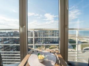 einen Balkon mit einem Tisch und Blick auf ein Gebäude in der Unterkunft Apartment Ravenna by Interhome in Middelkerke