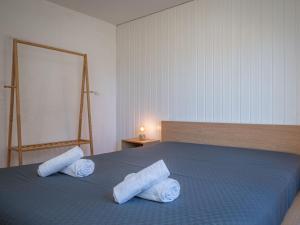 オヴロナにあるApartment Seya 15 by Interhomeのベッドルーム1室(ブルーベッド1台、ロールタオル2枚付)