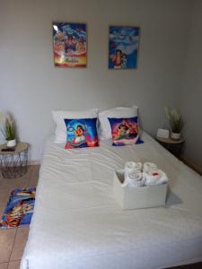 een wit bed met een doosje handdoeken erop bij C101 Appartement DisneyLand Montevrain in Montévrain