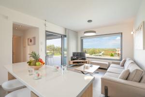a living room with a couch and a table at Sunset Villa in Paralia Dionysiou