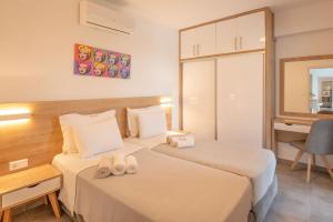 two beds in a hotel room with slippers on them at Sunset Villa in Paralia Dionysiou +30 photos