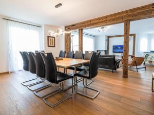 a dining room with a wooden table and black chairs at Apartment B21 by Interhome in Leukerbad