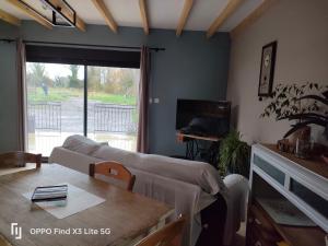 a living room with a couch and a table at Maisonnette à la campagne in Delettes