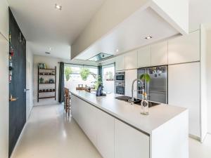 a kitchen with white cabinets and a counter top at Villa Villa Vosseslag - garage and big garden by Interhome in De Haan