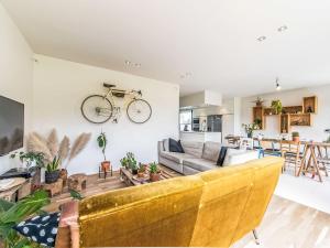 a living room with a couch and a bike hanging on the wall at Villa Villa Vosseslag - garage and big garden by Interhome in De Haan +11 photos
