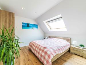 a attic bedroom with a bed and a window at Villa Villa Vosseslag - garage and big garden by Interhome in De Haan