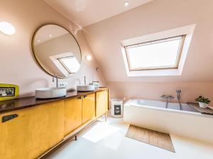 a bathroom with a large mirror and a tub at Villa Villa Vosseslag - garage and big garden by Interhome in De Haan