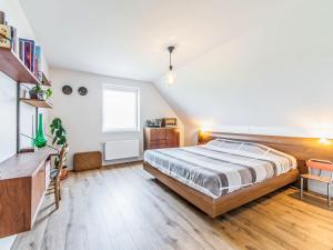 a bedroom with a large bed and a window at Villa Villa Vosseslag - garage and big garden by Interhome in De Haan