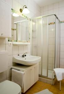 a white bathroom with a sink and a shower at Alpenpension Birkenhof in Grünau im Almtal