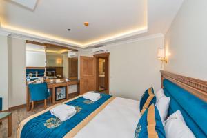 a bedroom with a large bed with a blue blanket at Byzantium Comfort Hotel in Istanbul +100 photos