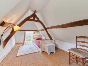 una camera mansardata con letto e sedia di Holiday Home 2 Chaumières normande by Interhome a Le Perrey Altre 25 foto