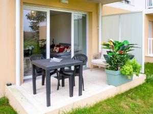une table noire et des chaises sur le porche d'une maison dans l'établissement Apartment Atlantica-2 by Interhome, à Pornic
