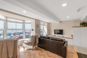 a living room with a couch and a tv at Popular Sea View Apartment in Aberdyfi