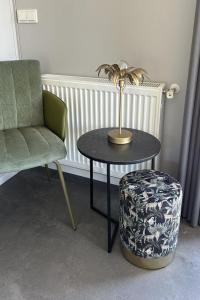 einen Tisch mit einer Lampe, einem Stuhl und einem Stuhl in der Unterkunft Holiday Home Noordzee Deluxe 32 by Interhome in Scherpenisse