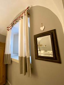a mirror on a wall next to a window with curtains at B&B Corte Santa Maria in Rovereto +89 photos