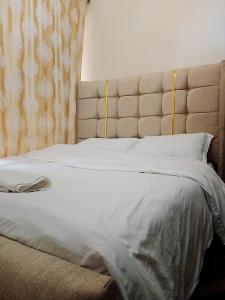 a large bed with a large headboard in a bedroom at Classy Spacious Studio - Waiyaki Way in Rungiri