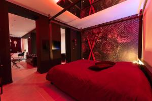 a bedroom with a red bed with a red wall at Nuit D'or - Royale Room in Épernay