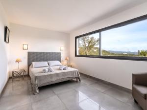 een slaapkamer met een bed en een groot raam bij Villa Villa Lamas by Interhome in Sainte-Lucie de Porto-Vecchio