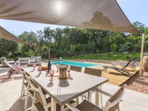 een tafel met wijnglazen op een patio met een zwembad bij Villa Villa Lamas by Interhome in Sainte-Lucie de Porto-Vecchio +36 foto's