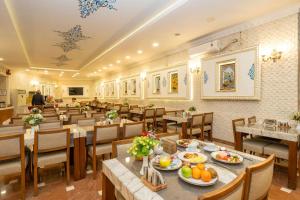 a restaurant with tables and chairs with food on them at Byzantium Comfort Hotel in Istanbul