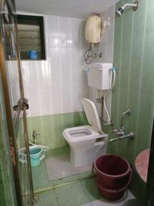 a small bathroom with a toilet and a sink at holiday homes in Murud