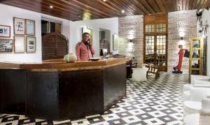 a man standing at a bar in a room at Hôtel La Résidence in Saint-Louis