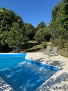 two chairs sitting next to a swimming pool at Casita de Cuesta in Villa Icho Cruz