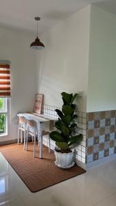 a dining room with a table and a potted plant at BN Villa Walk to Bangtao Beach Near Markets in Phuket