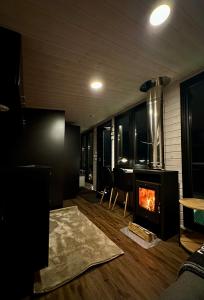 a living room with a fireplace and a table at Aurora Forest Cabin in Rovaniemi