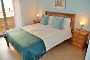 a bedroom with a large bed with blue pillows at Santo Amaro Apartments in Lagos