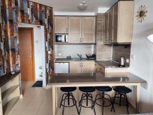 Una cocina con gabinetes de madera y taburetes de bar. en Belvedere Holiday Club H41, en Bansko