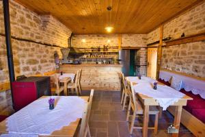 a restaurant with tables and a kitchen in the background at Argyropolis Boutique Hotel in Gjirokastër