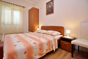 a bedroom with a bed and a dresser and a window at Apartments Ivanka C. in Soline