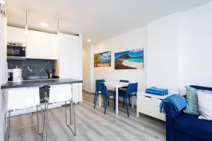 a kitchen and living room with a table and chairs at Home2Book Ocean Breeze Terrace Stay, Mesa del Mar in Puerto de la Madera