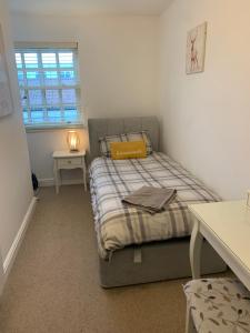 a bedroom with a bed and a table and a window at 2 Bedroom duplex apartment in Bawtry
