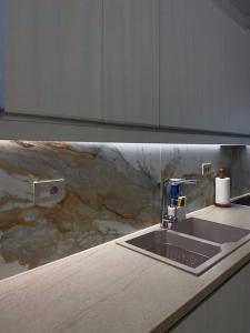 a kitchen with a sink and a marble counter top at Central in Argostoli +10 photos