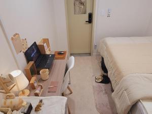 a bedroom with a desk with a laptop computer on it at Stay Aall Seoul Train Station 2 in Seoul
