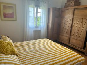 a bedroom with a striped bed and a window at Le Grenier at Garos in Garos