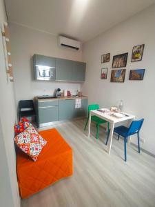 Una sala de estar con mesa y sillas y una cocina. en Biga Guest House - Intero appartamento Milano, en Milán