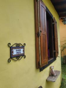 a sign on the side of a building with a window at Pousada Villa di Lavras in Lavras Novas
