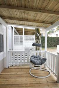 a porch with a rocking chair on a deck at Holiday Home Happy Superior by Interhome in Marina di Bibbona
