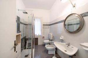 un bagno con lavandino, WC e specchio di Casa Nina ad Arenzano Altre 10 foto