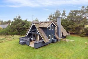 灵克宾Feriehus 1072的田野上茅草屋顶的房子