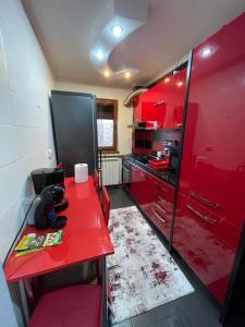 cocina con armarios rojos y mesa roja en Cosy Home Apartament, en Craiova
