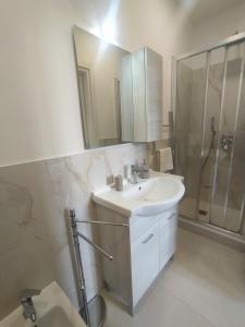 Un baño blanco con lavabo y ducha. en Biga Guest House - Intero appartamento Milano, en Milán