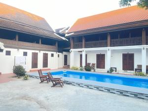 a courtyard with two chairs and a swimming pool at Residence Boutique Hotel in Luang Prabang