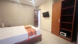 ein kleines Schlafzimmer mit einem Bett und einem Fernseher in der Unterkunft VIILA VEAR in Canggu