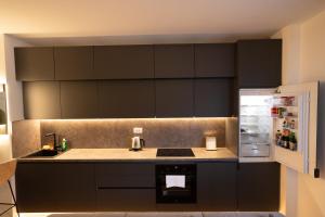a kitchen with black cabinets and an open refrigerator at ToRo Hospitality in Mostar +78 photos
