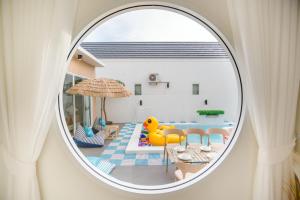 a round window in a room with a pool at Cloud9 Pool Villa in Cha Am
