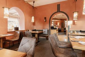 a restaurant with wooden tables and chairs and an archway at Staudacherhof in Garmisch-Partenkirchen I Blick aufs Zugspitzmassiv I einzigartige Bayurvida Küche in Garmisch-Partenkirchen
